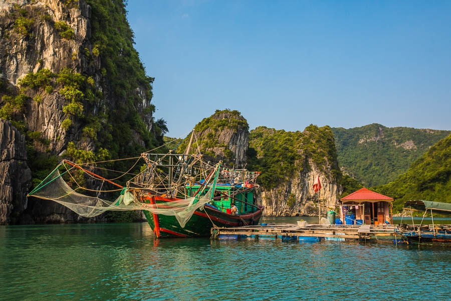 Floating fishing villages thrive in the bay’s calm waters.